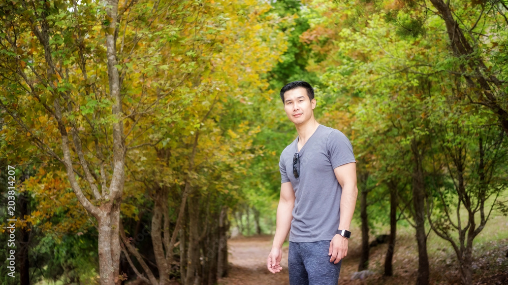 Asian young men standing in front of a maple tree. Asian young men standing in front of a maple tree.