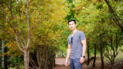 Asian young men standing in front of a maple tree.