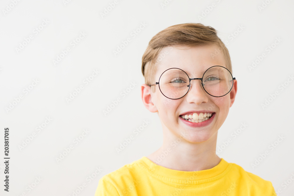 Handsome laughing teen boy with big glasses and yellow t-shirt
