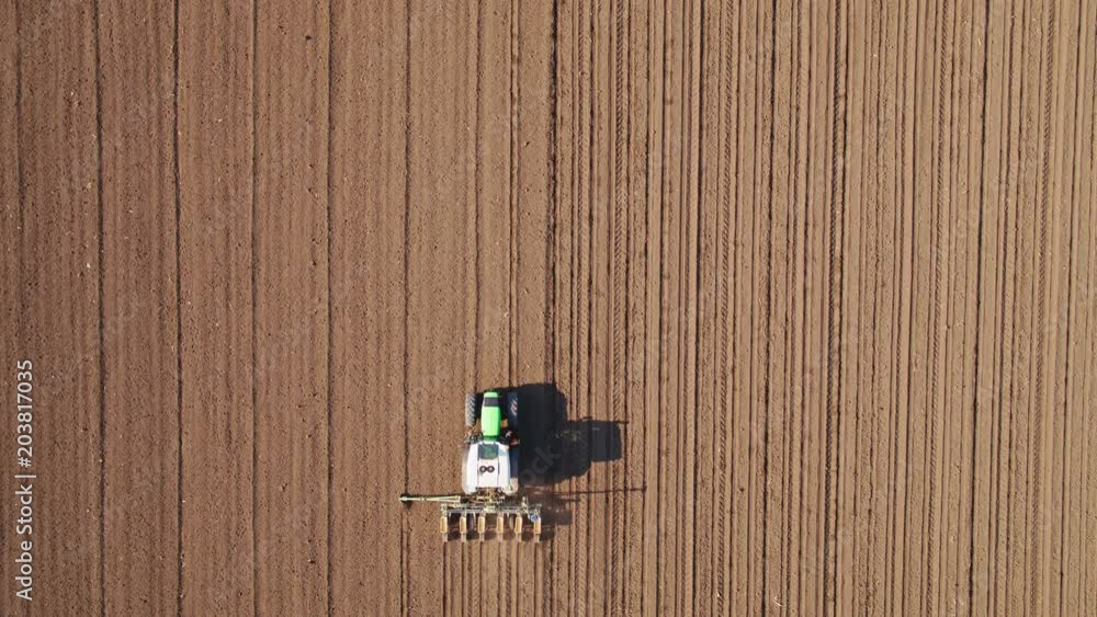 Aerial shot of a farmer seeding, sowing crops at field. Aerial shot of a farmer seeding, sowing crops at field.