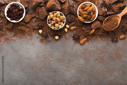Crushed chocolate pieces and cocoa on gray background, top view