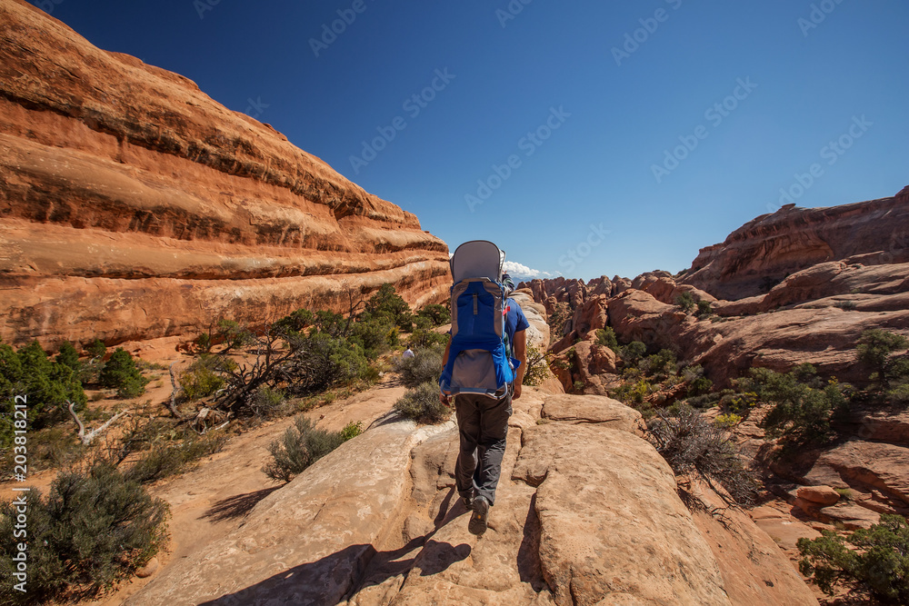 Hiker rests in Arches National park in Utah, USA