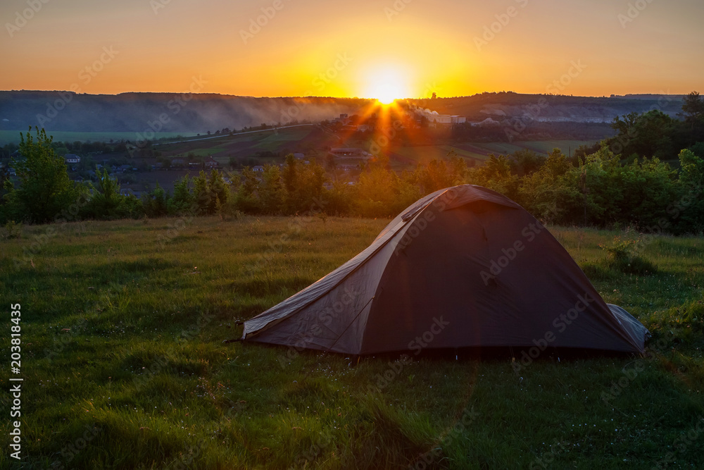 Tourist tent at sunrise near the fire.