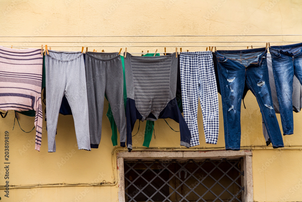 Clothes hang on the rope. clothes dry on the wall of the house, drying  after washing Stock Photo