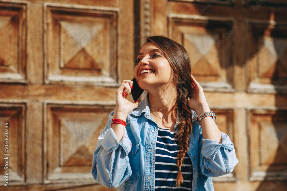 Φωτογραφία Young woman receiving good news over the phone in the city