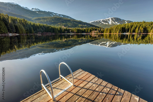 Early morning sunlight on the dock at Lost Lake in Whistler, British Columbia, Canada photo