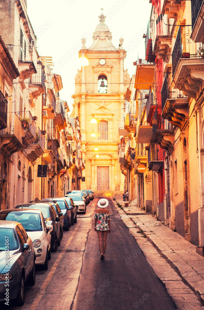 Fototapeta premium The girl standing on the street of Ragusa, Italy.