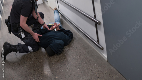 Obraz na plátně Prison guard right inmate resisting arrest in prison after commiting crime