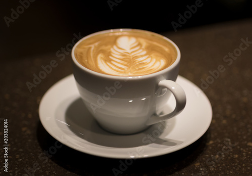 Fresh cappuccino on wooden table