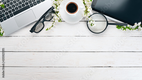Laptop with coffee and flowers. Business. On a wooden background. Top view. Copy space.