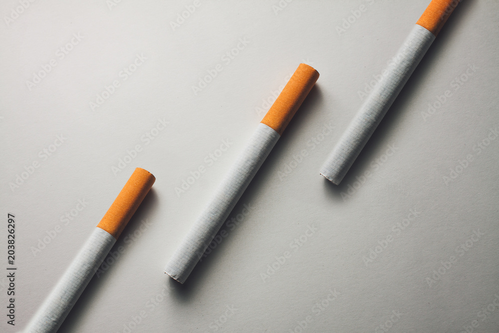 close-up of three cigarettes on a white surface