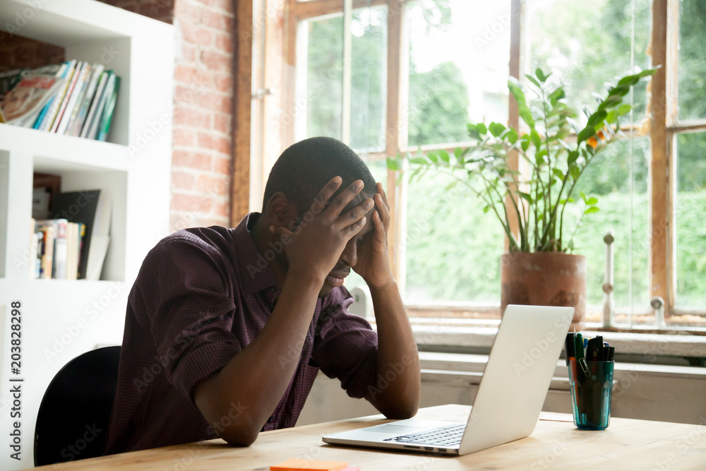 Φωτογραφία Frustrated African American worker disappointed with company business collapse, falling rates and bankruptcy news