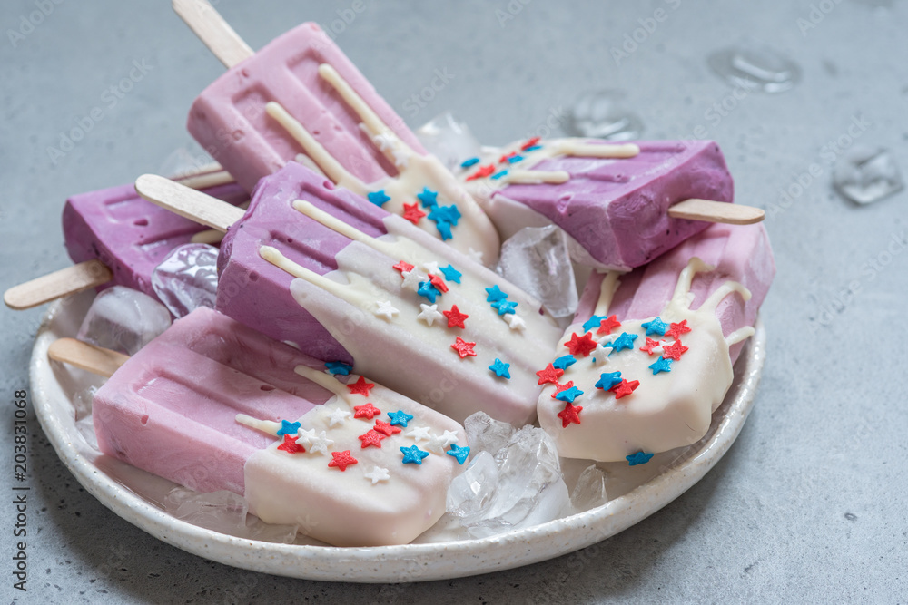 Yogurt popsicles topped with white chocolate and american stars sprinkles Yogurt popsicles topped with white chocolate and american stars sprinkles