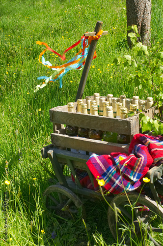 A handcart with a blanket, a beer box, colorful ribbons on a wonderful spring meadow for fathers day