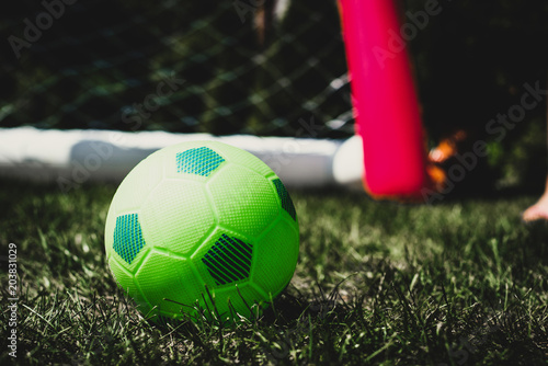 A green ball located on the grass against the background of the goal. photo