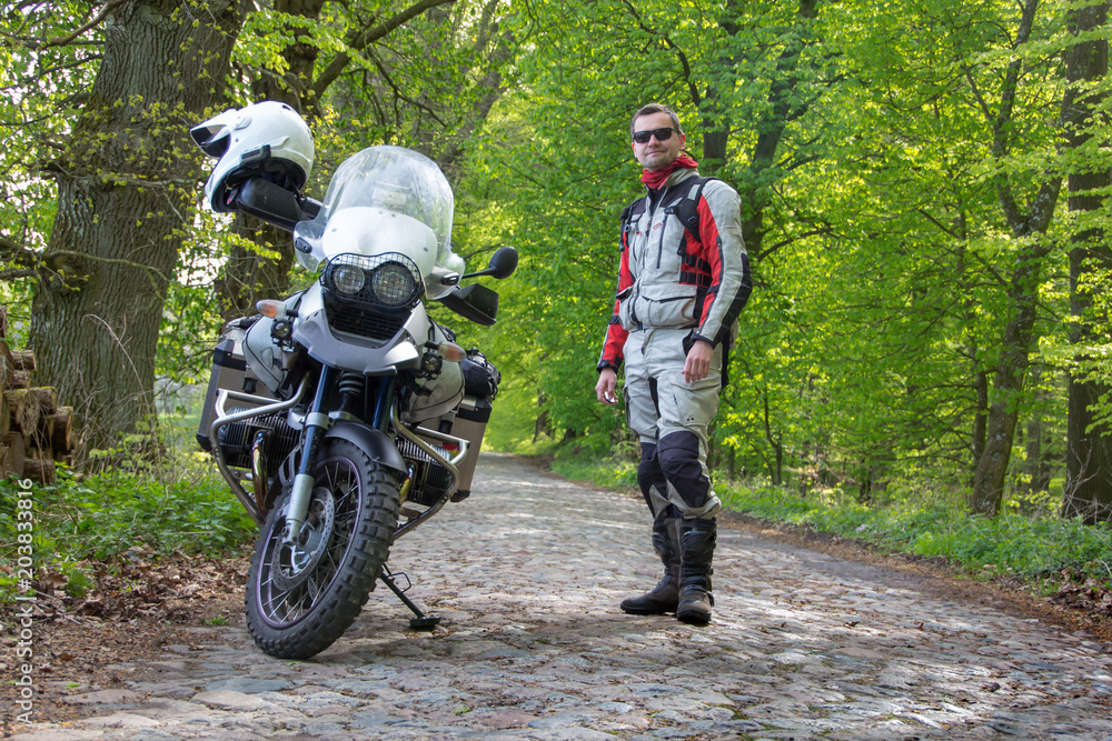 Fototapeta premium Reiseenduro Motorrad im Wald mit Fahrer - Blick in die Ferne