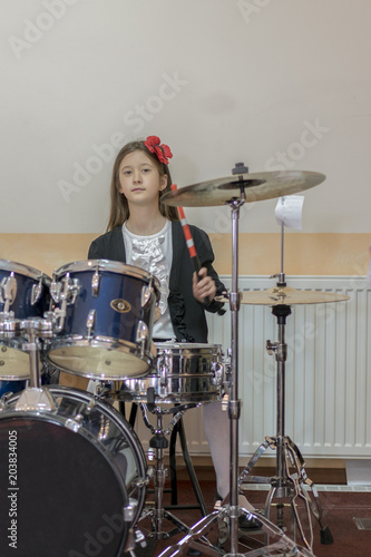 young caucasian teenage girl plays the drums. girl playing the