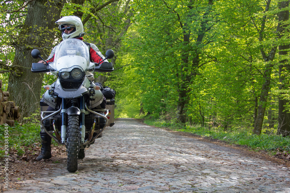 Fototapeta premium Podróżuj motocyklem enduro po lesie z kierowcą - patrząc w dal