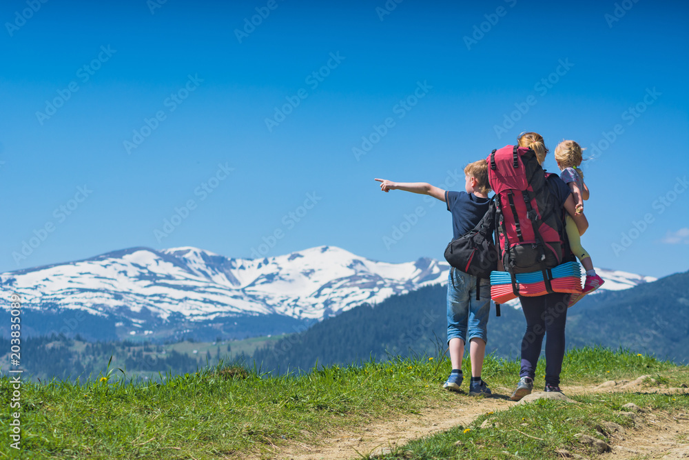 Mother hiker with her children standing on a hill Mother hiker with her children standing on a hill