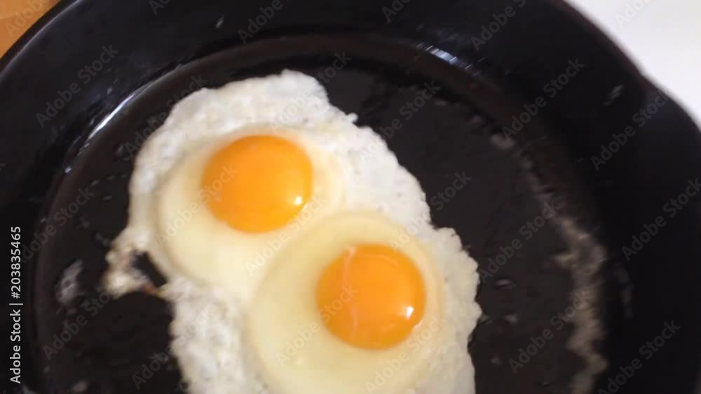Eggs being fried in well seasoned cast iron frying pan, eggs slide effortlessly around the non stick cast iron surface due to the Eggs being fried in well seasoned cast iron frying pan, eggs slide effortlessly around the non stick cast iron surface due to the