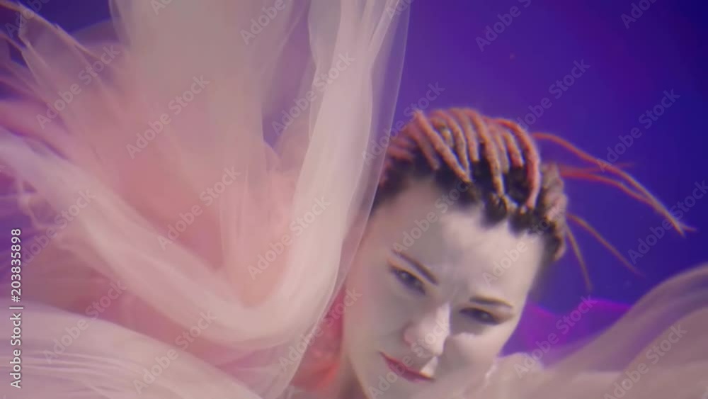 the mystical woman is under water in the depths of the sea, the lady slowly moves her hands, she has dreadlocks the mystical woman is under water in the depths of the sea, the lady slowly moves her hands, she has dreadlocks
