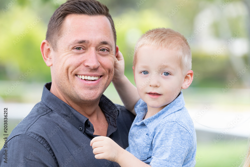 Young Caucasian Father and Son Having Fun At The Park Young Caucasian Father and Son Having Fun At The Park