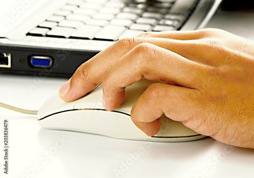 hand with mouse on PC keyboard on table