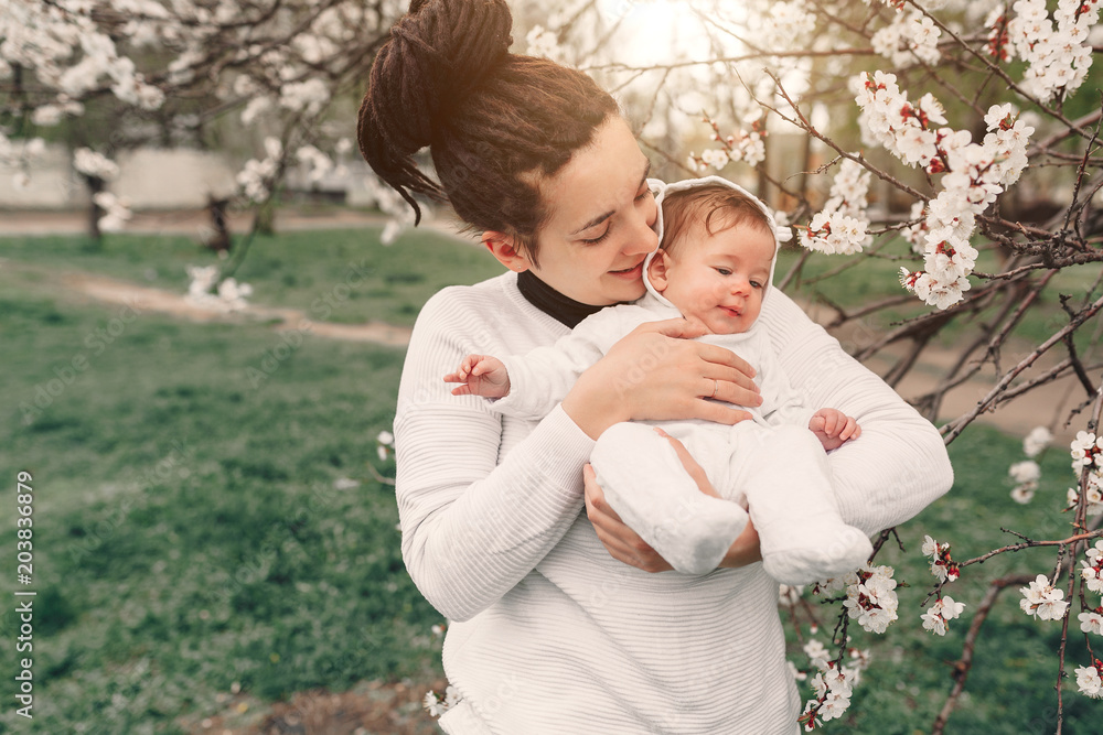 young mother with adorable daughter in park with blossom tree. Happy mother and child young mother with adorable daughter in park with blossom tree. Happy mother and child