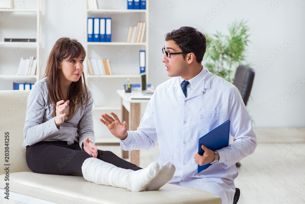 Fototapeta premium Doctor examining patient with broken leg