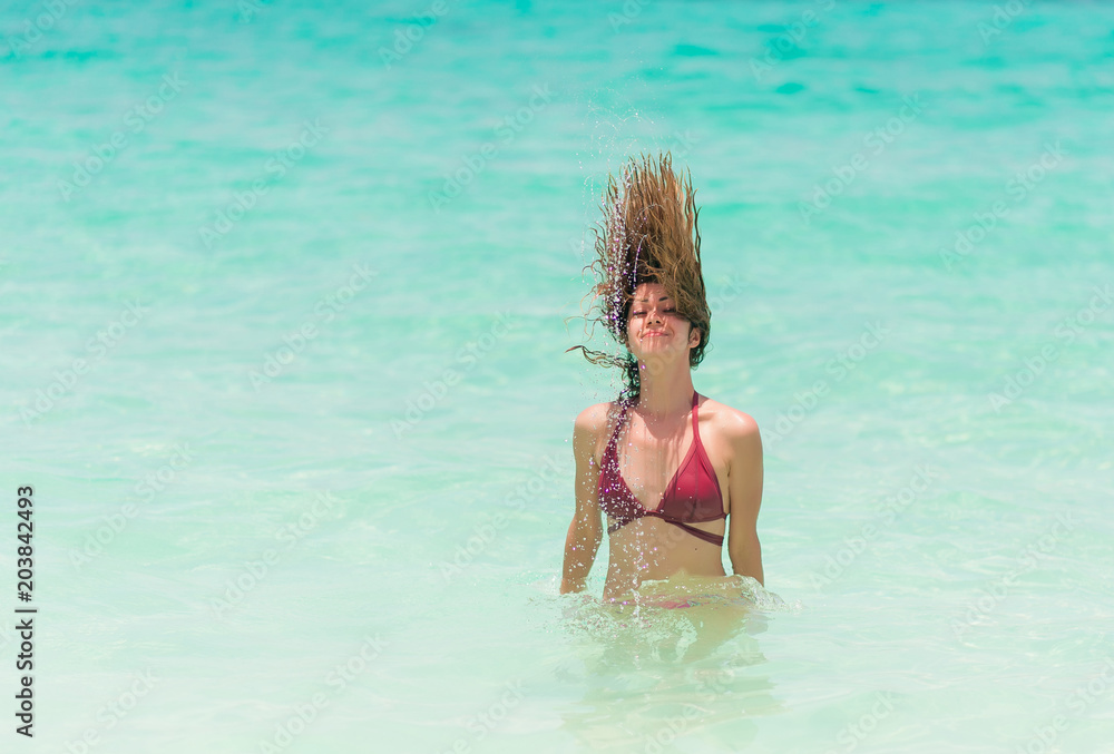 Happy woman in red bikini is playing and splashing in the sea Happy woman in red bikini is playing and splashing in the sea