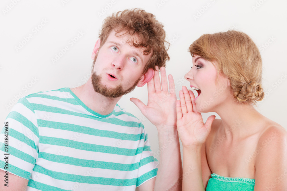 Woman telling an astonished man some secrets
