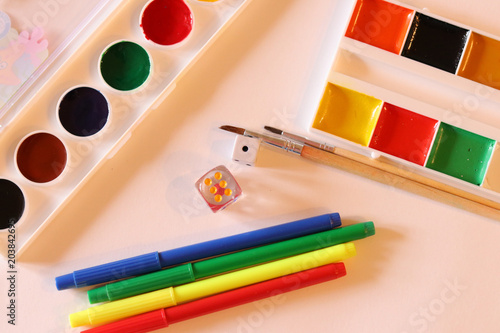 School supplies on the white background: watercolor, pencils and brushes. School and education. Colorful accessories. Preparation for school. Art composition. Drawing and painting.