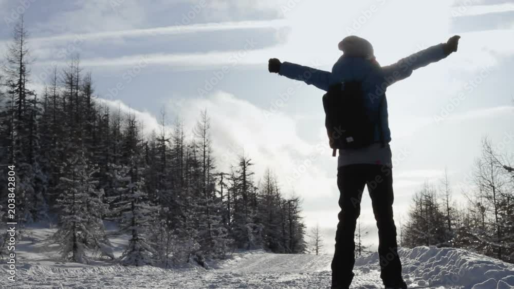 Happy woman standing in the snowy landscape with arms outstretched Happy woman standing in the snowy landscape with arms outstretched