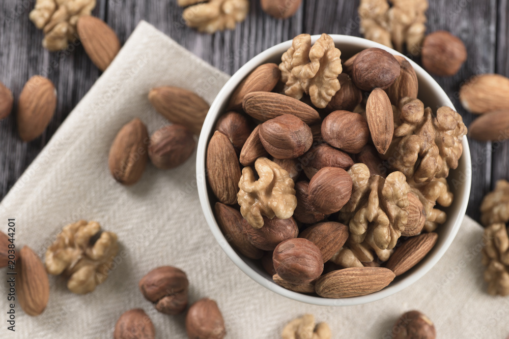 Mixed nuts - hazelnuts, walnuts, almonds in white bowl Mixed nuts - hazelnuts, walnuts, almonds in white bowl