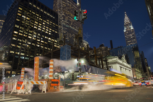 Canvas Print Long exposure photo of cars crossing an intersection in New York City while steam coming out from the manhole