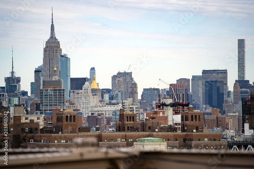 Manhattan skyline seen from the beautiful Brooklyn bridge. Cloudy day in New York City  USA.