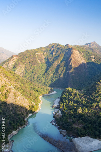 Wonderful green peaks of some mountains with the Ganges river flowing between them in Rishikesh, India