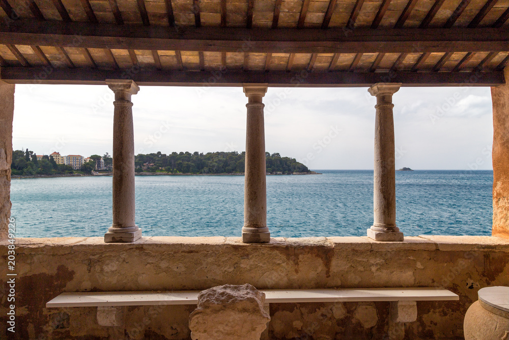 View through an antique building of Rovinj town on Adriatic sea, one of major tourist attractions at Istria in Croatia, Europe.