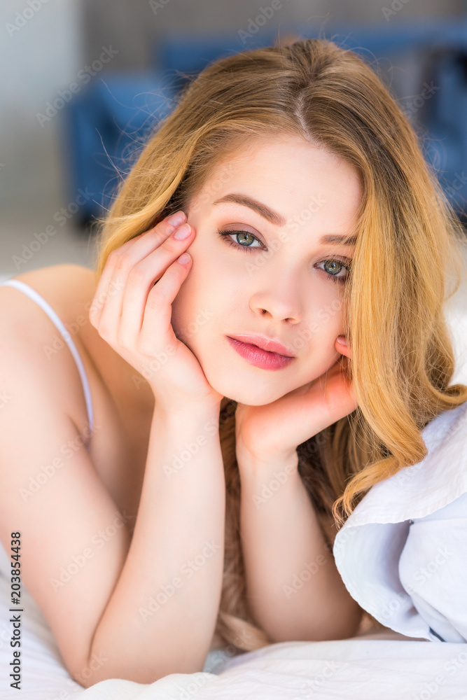 Naklejka premium portrait of attractive dreamy girl lying in bed