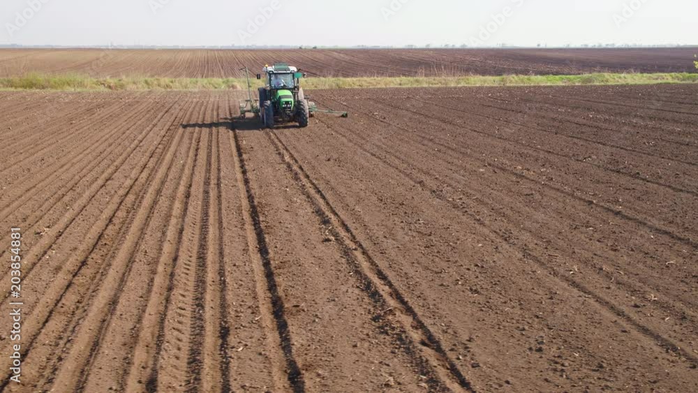 Aerial shot of a farmer seeding, sowing crops at field. Aerial shot of a farmer seeding, sowing crops at field.