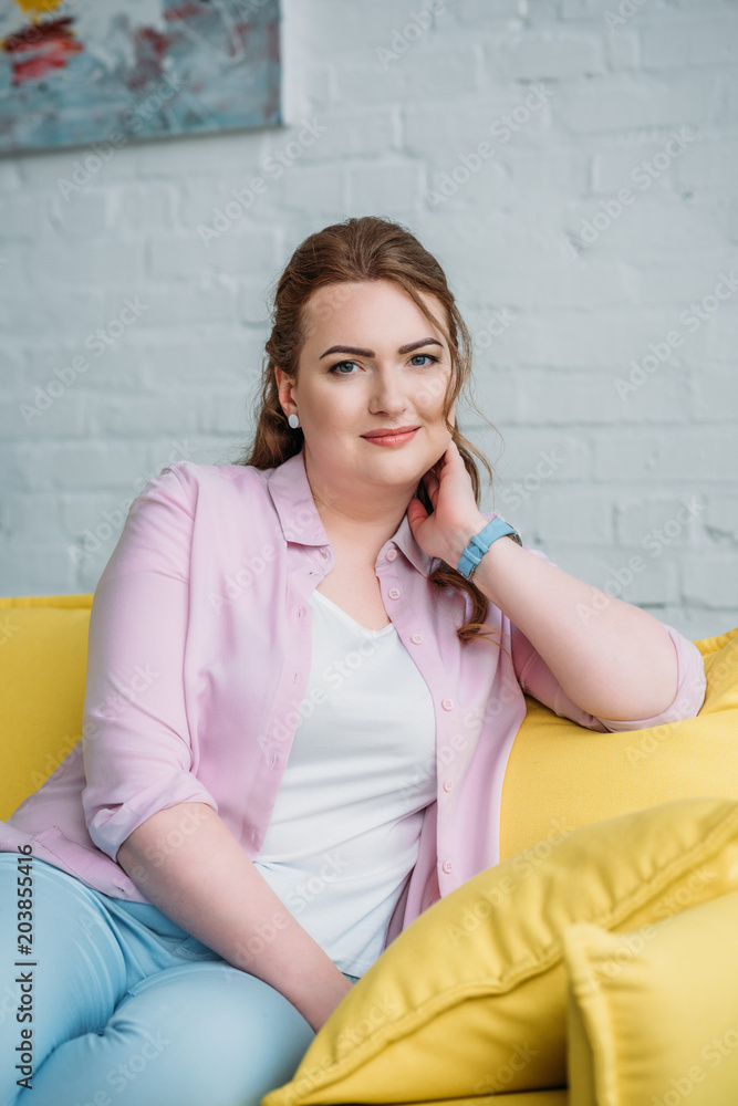portrait of beautiful woman sitting on sofa and looking at camera at home portrait of beautiful woman sitting on sofa and looking at camera at home