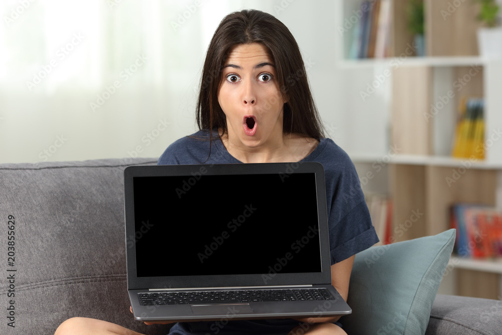 Amazed teen showing you a blank laptop screen Amazed teen showing you a blank laptop screen