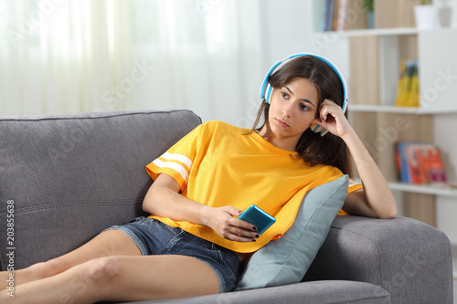 Serious teen listening to music online at home