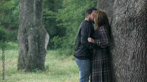 jealousy scene- young lovers kissing under a tree in the park ex violent boyfriend arriving