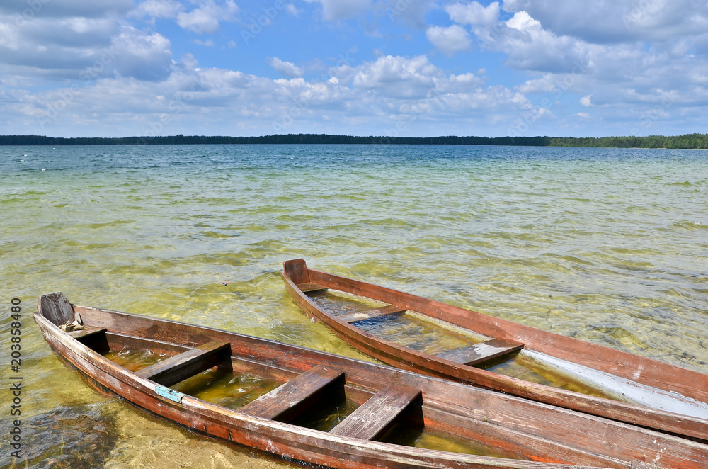 Old wooden fishing boats on the lake beach with blue sky. Old wooden fishing boats on the lake beach with blue sky.