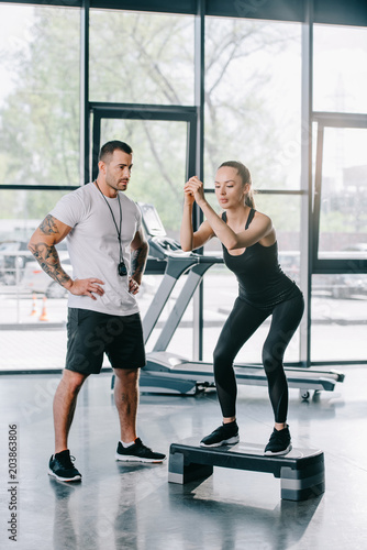 male personal trainer and young sportswoman doing step aerobics exercise at gym © LIGHTFIELD STUDIOS