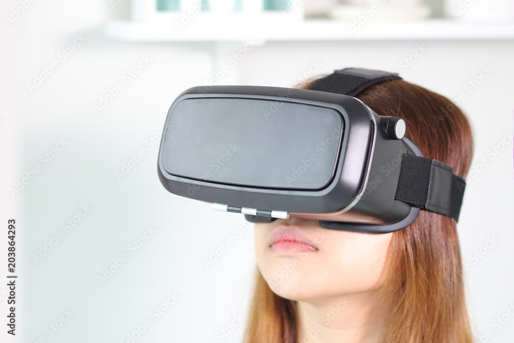 Young woman wearing virtual reality glasses at home. Young woman wearing virtual reality glasses at home.