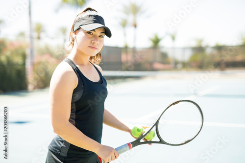 Cute tennis player training on court