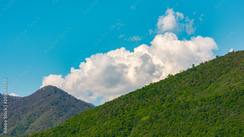 Cumulus clouds over green mountains