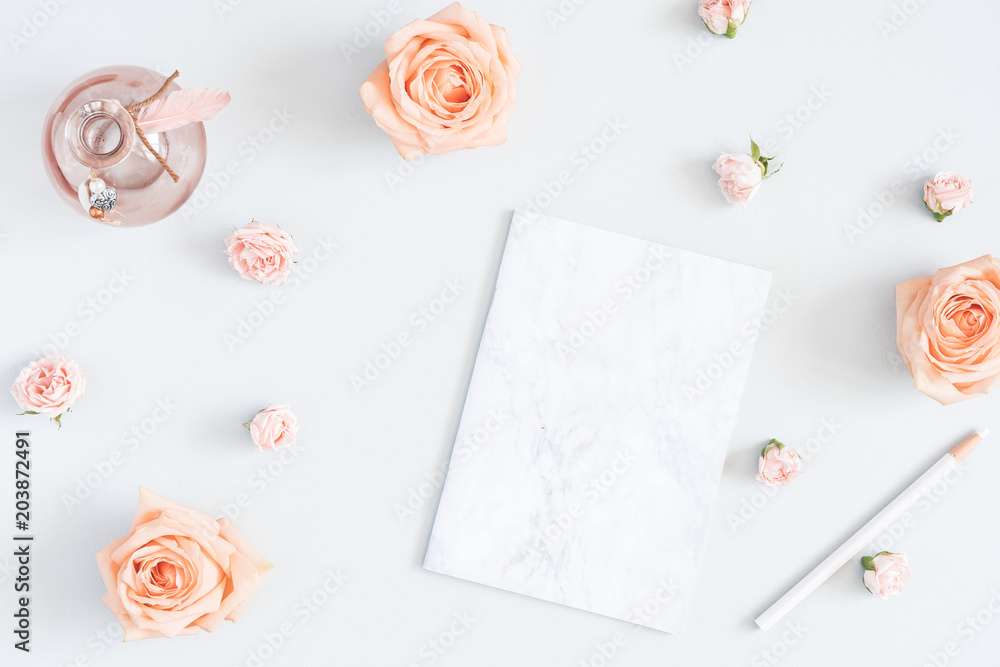 Feminine workspace with notebook, rose flowers, marble paper blank. Flat lay, top view, copy space - obrazy, fototapety, plakaty 